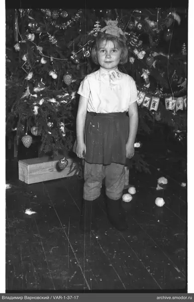 Mädchen vor geschmücktem Weihnachtsbaum