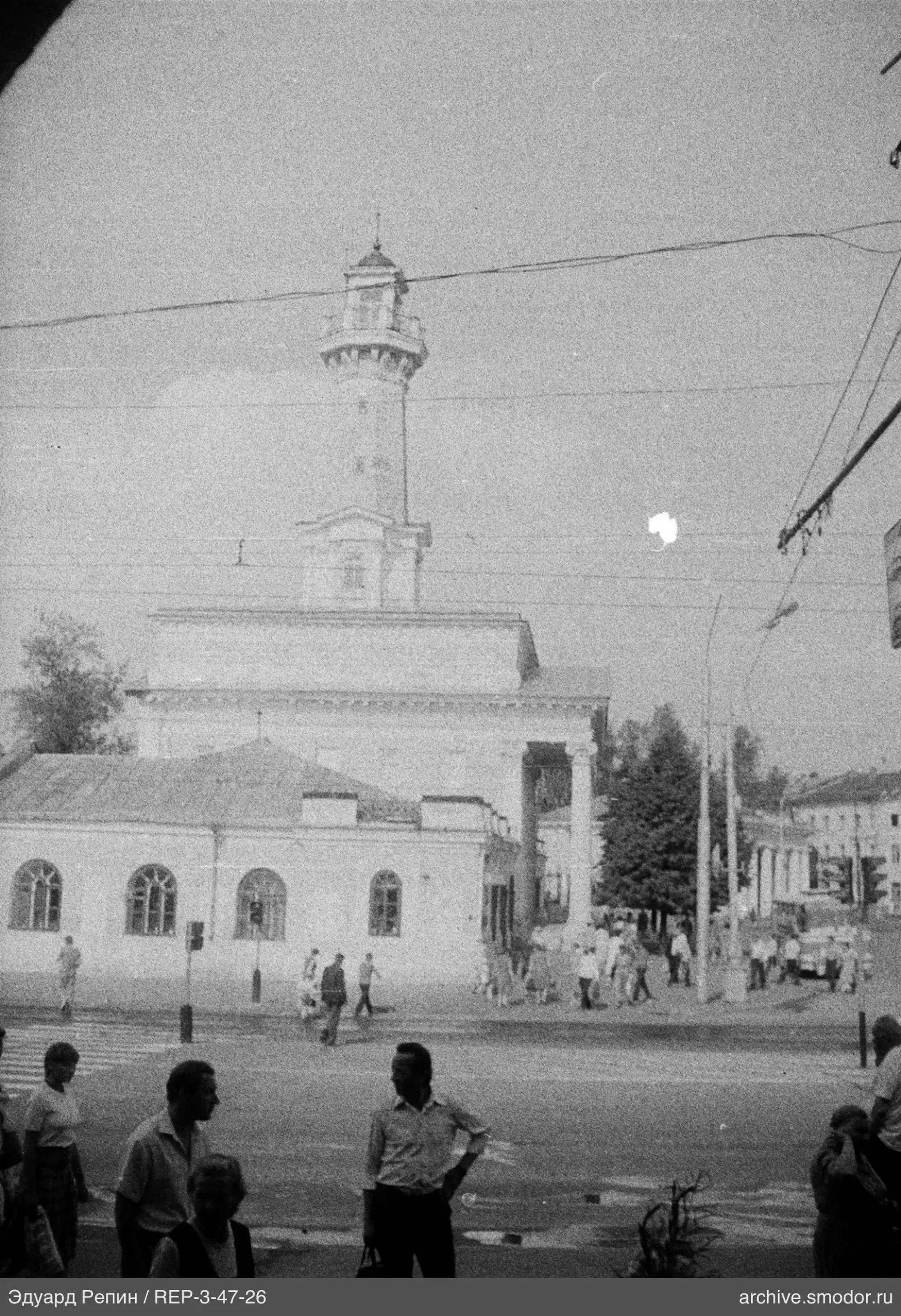 Улица с пешеходами и зданием с башней