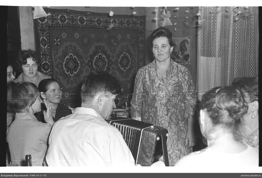 Woman in patterned dress and man playing bayan