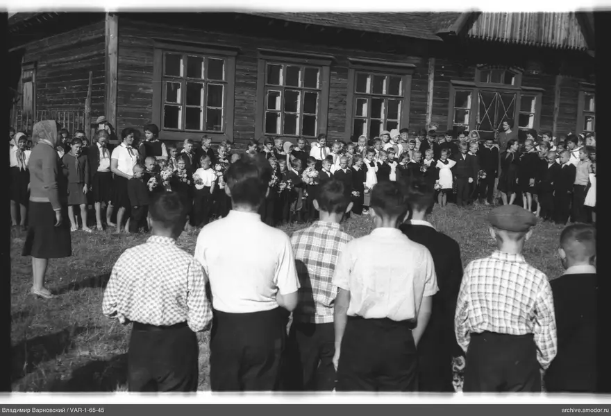 Gruppe von Kindern und Erwachsenen vor einem Gebäude