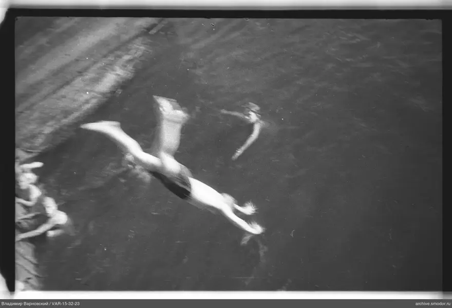 Zwei Personen im Wasser, eine springt