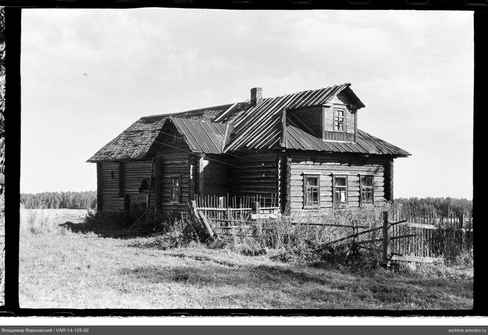 Holzhaus mit zwei Dächern und Zaun