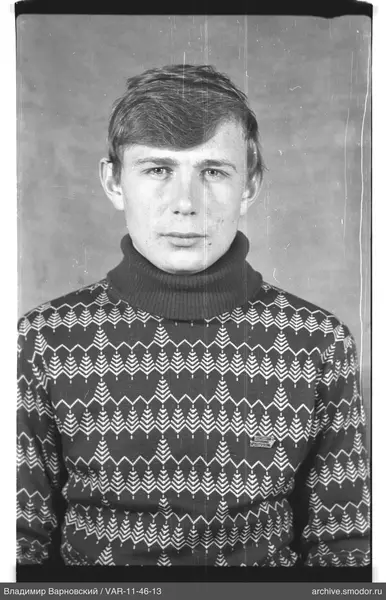 Porträt eines Mannes in einem Musterpullover mit Abzeichen
