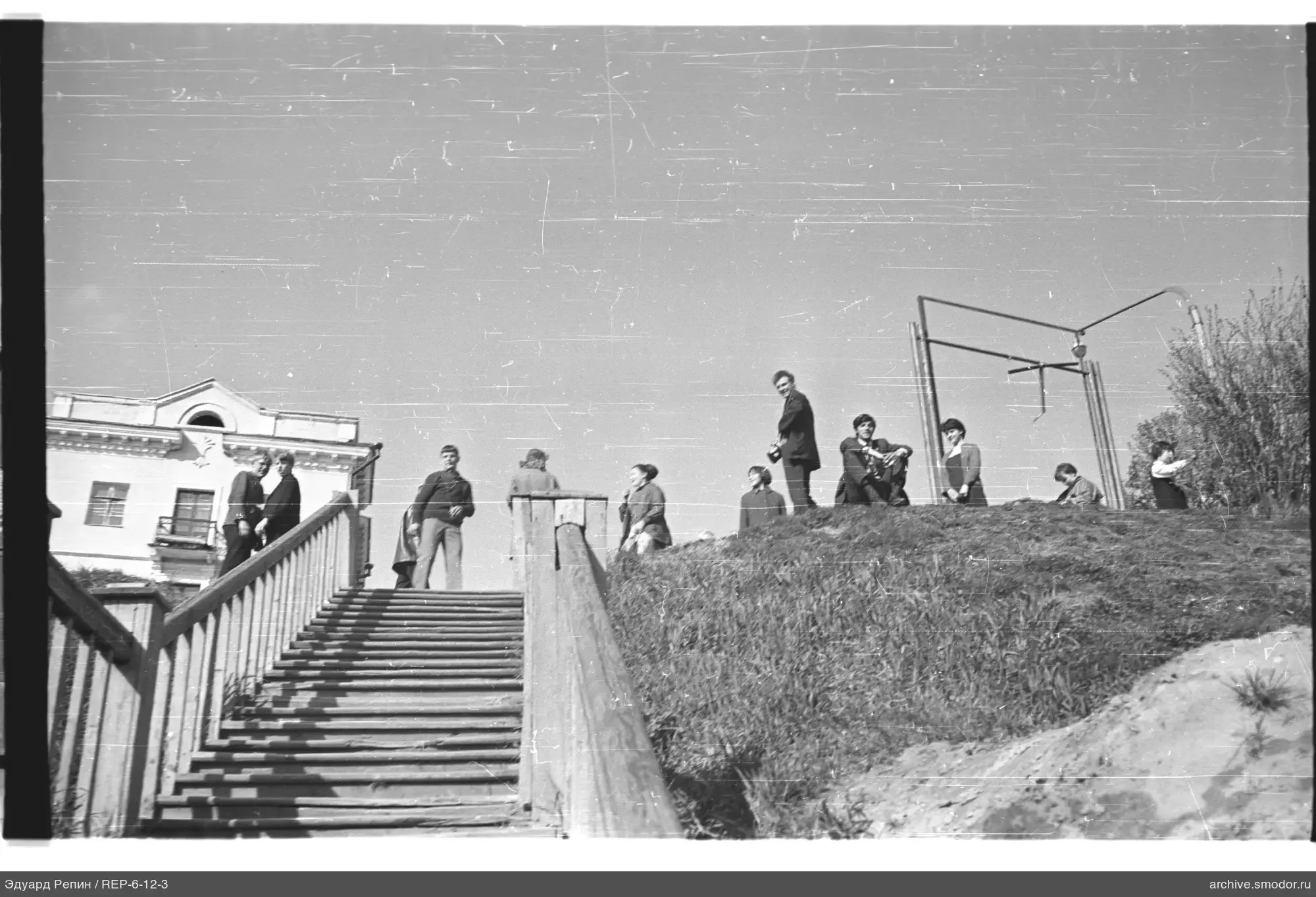People on the hilltop next to a structure