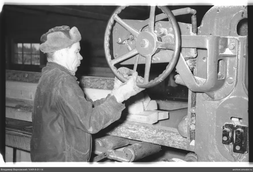 Mann an einer Maschine mit Holzstücken