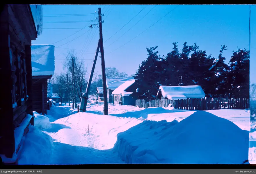 Snow-covered street with wooden houses