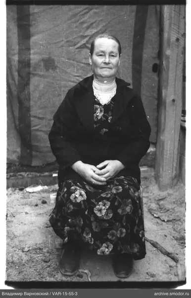 Frau in dunklem Mantel und Blumenmuster