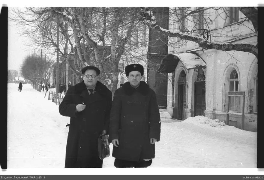 Два мужчины на зимней улице у здания
