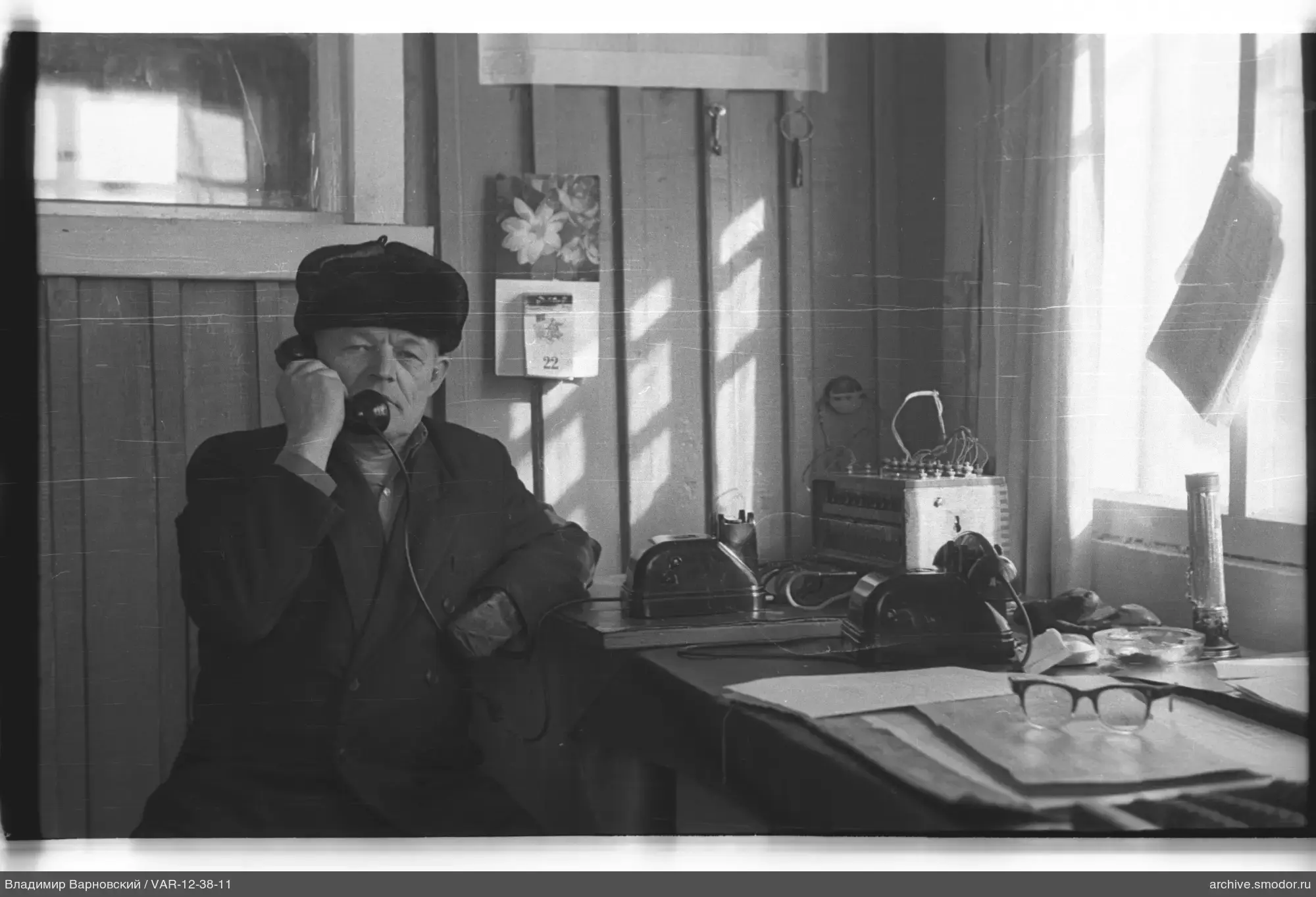 Mann mit Telefon an Holzwand
