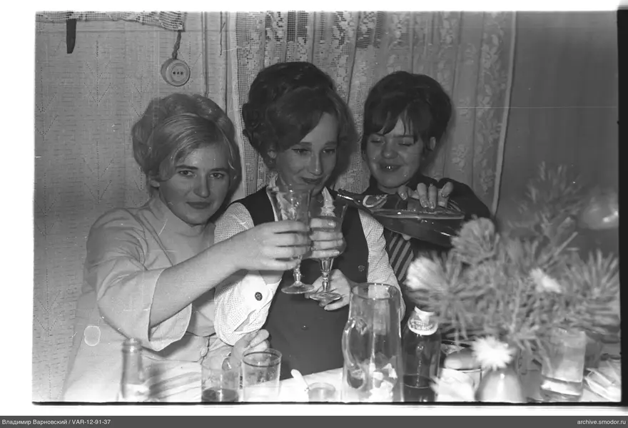 Drei Frauen an einem Tisch mit Geschirr und Flaschen