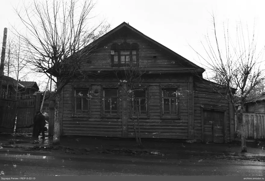 Holzhaus mit Bäumen und Personen
