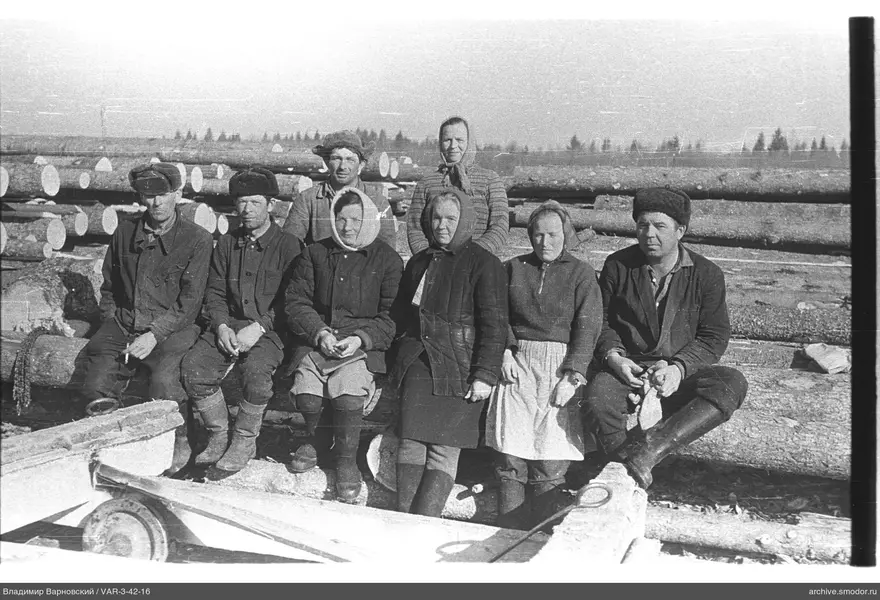 Group of people with logs and wooden structure