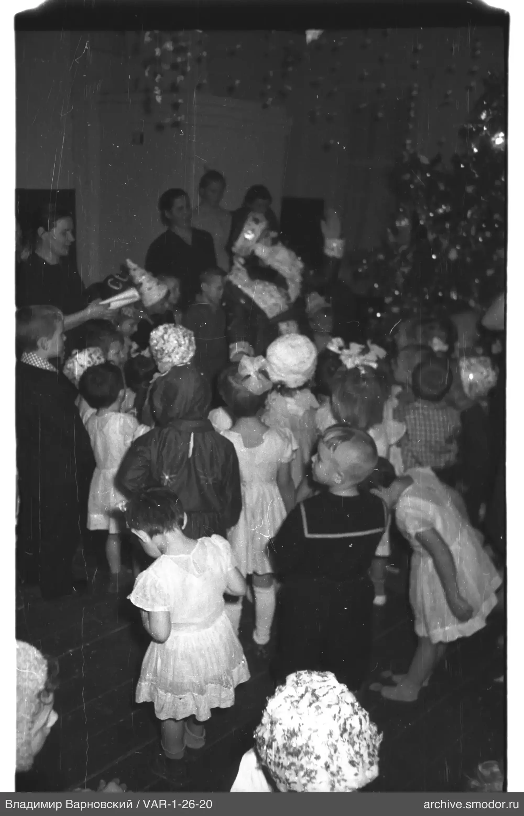 Children with gifts near decorated Christmas tree