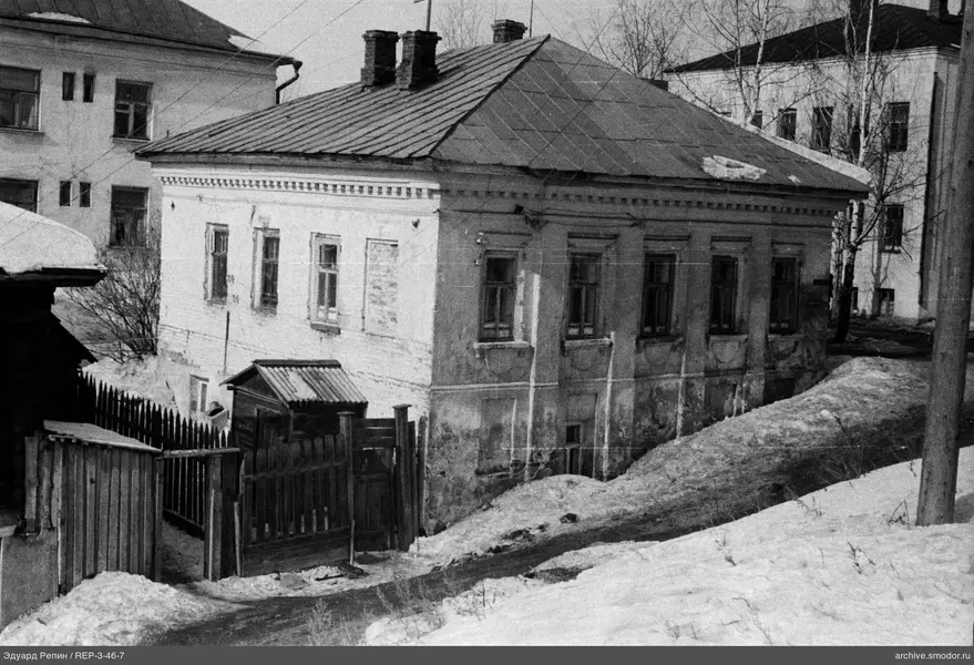 Zweistöckiges Haus mit Schornsteinen und Zaun