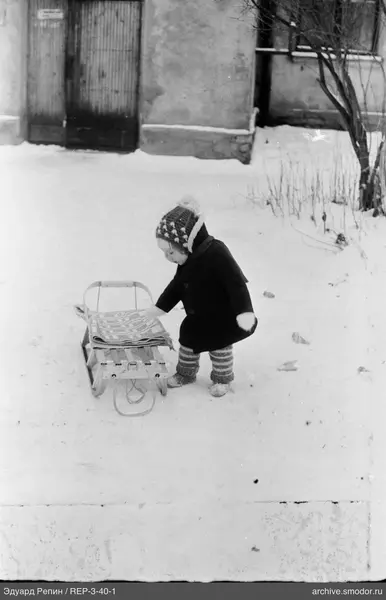 Kind mit Schlitten im Schnee