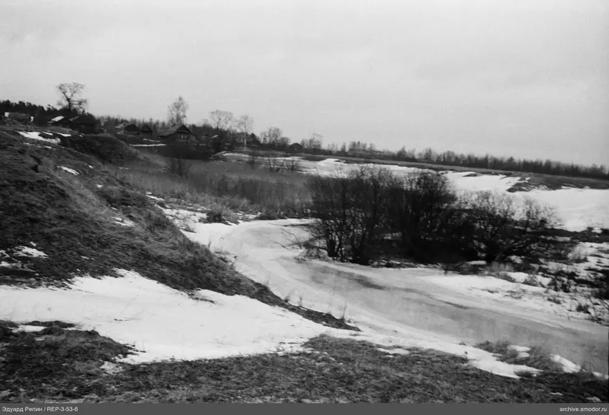 Verschneite Landschaft mit Häusern und Fluss