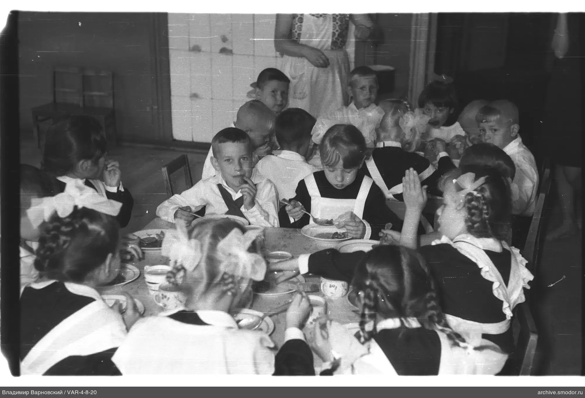 Kinder in Schuluniformen am Tisch