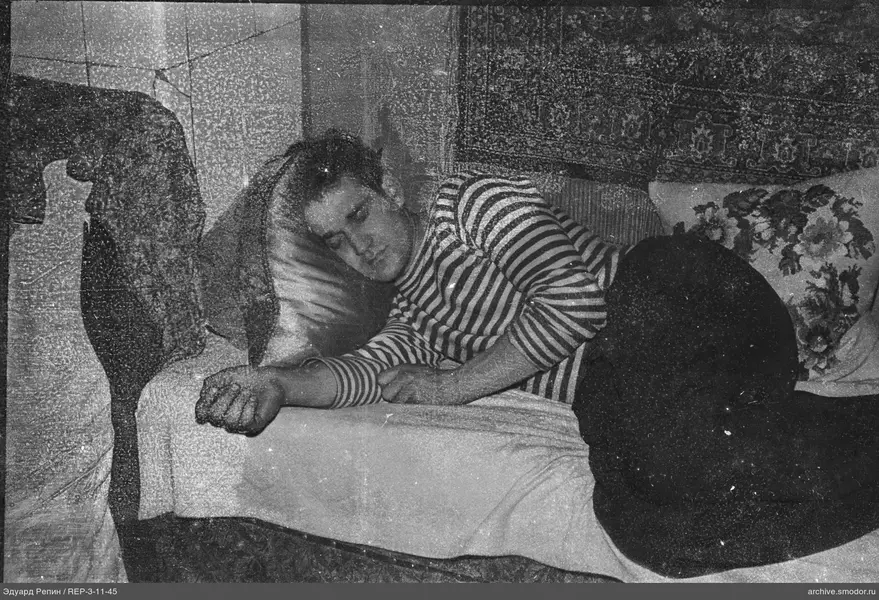 Mann auf Sofa mit Kissen und Teppich
