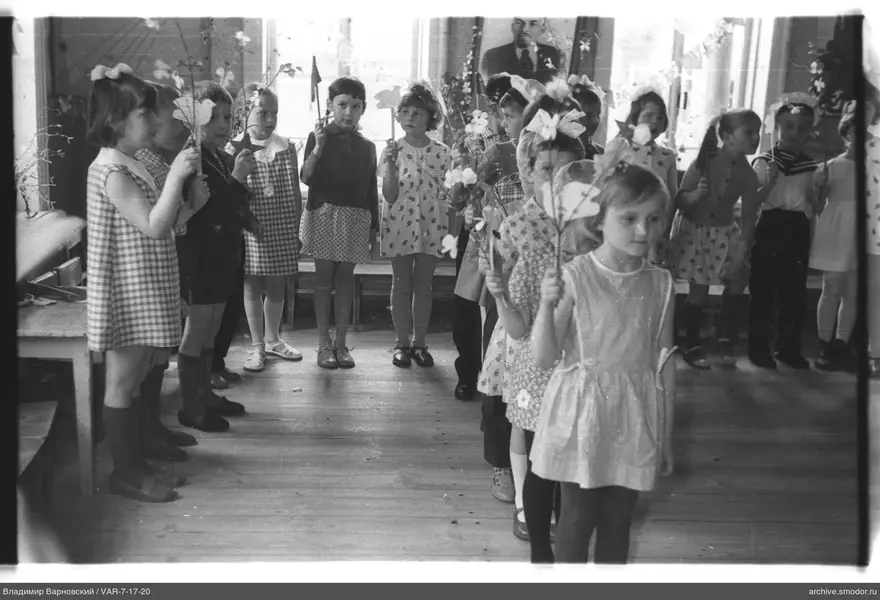 Gruppenaufnahme von Kindern mit Blumen und Papierfiguren