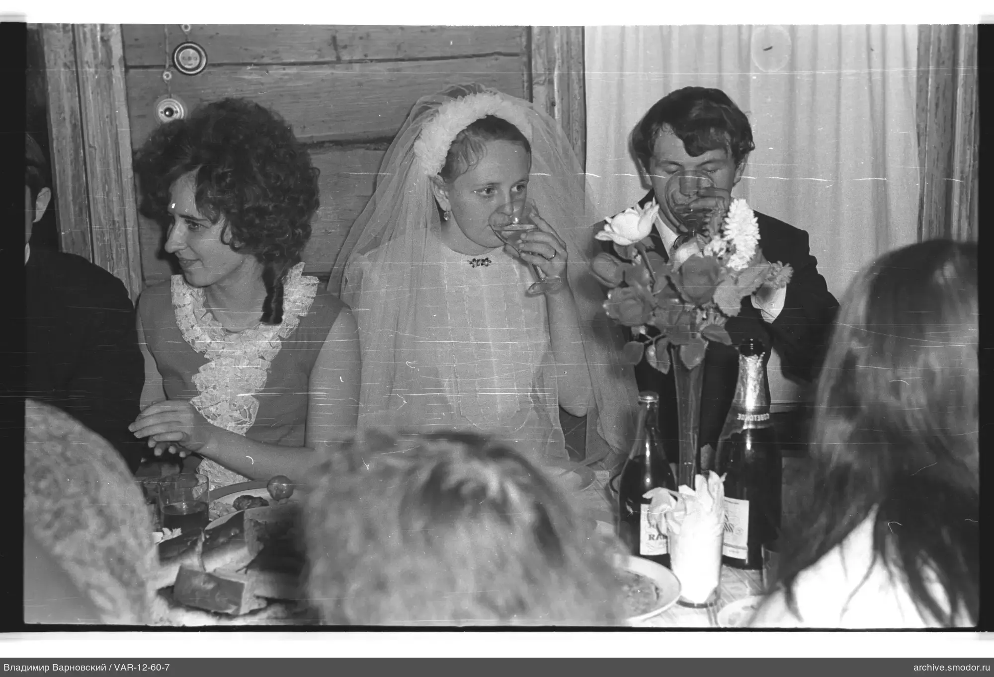 Gruppe am Tisch mit Braut im Hochzeitskleid