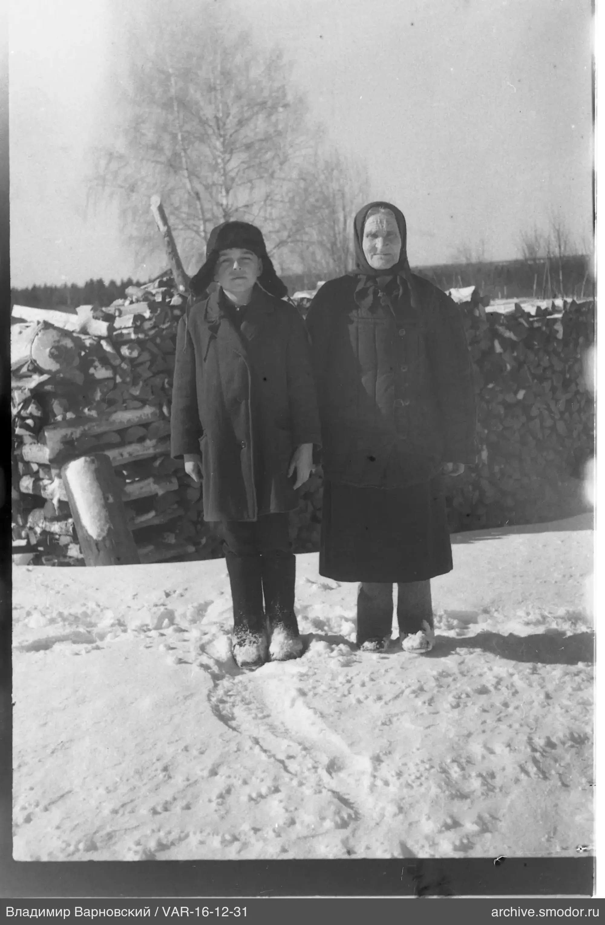 Zwei Frauen im Schnee bei Brennholz