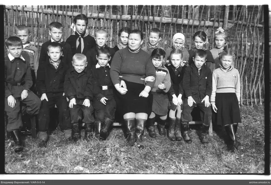 Gruppe von Kindern und Frau auf einer Bank
