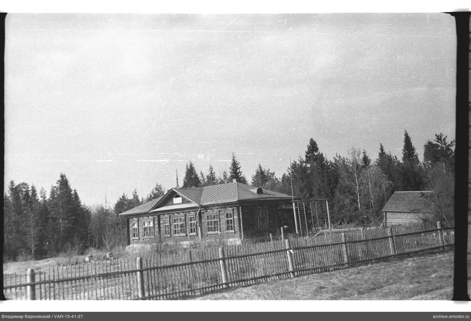Holzgebäude mit Zaun und Schuppen