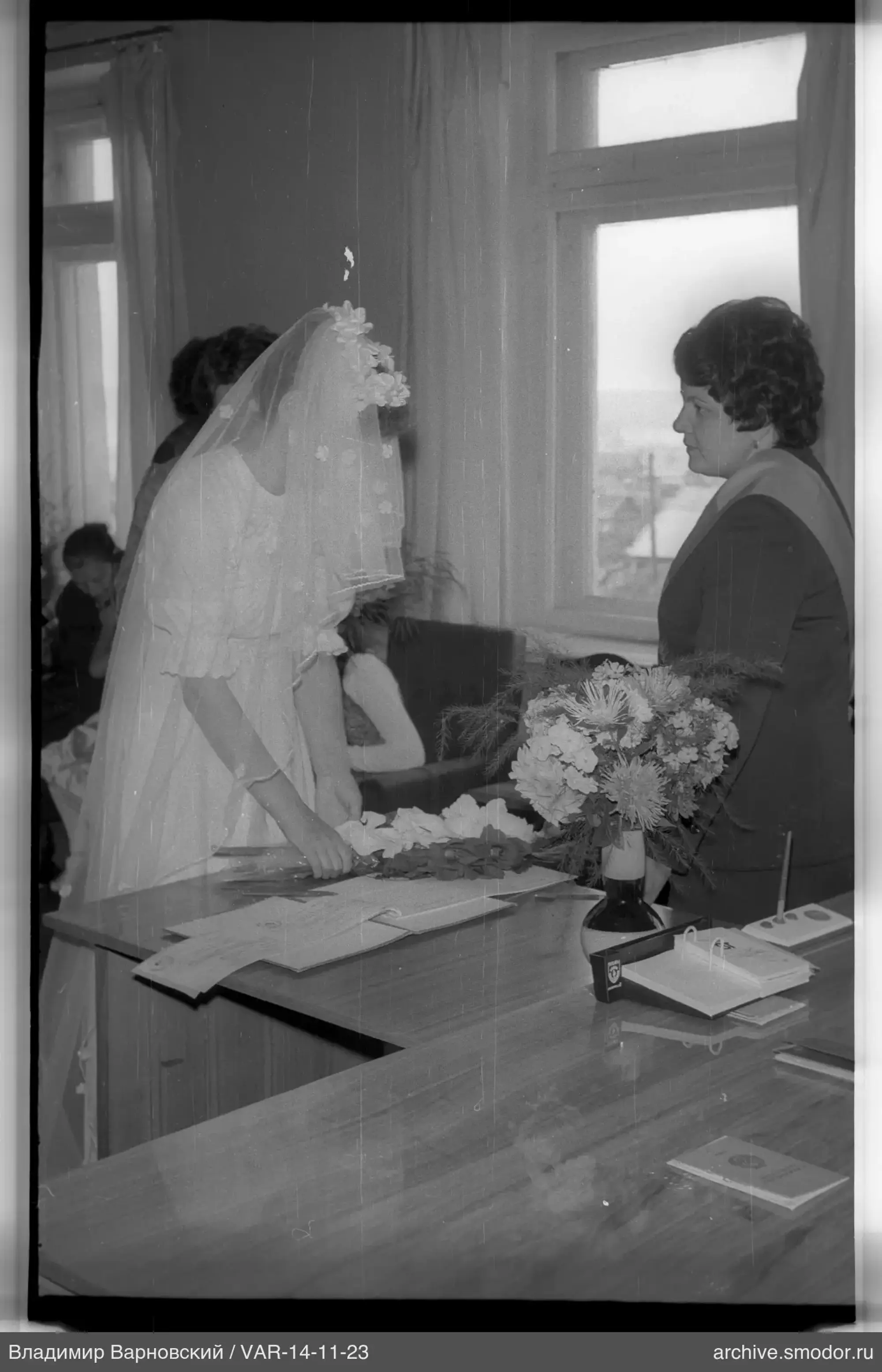 Woman in wedding dress at table