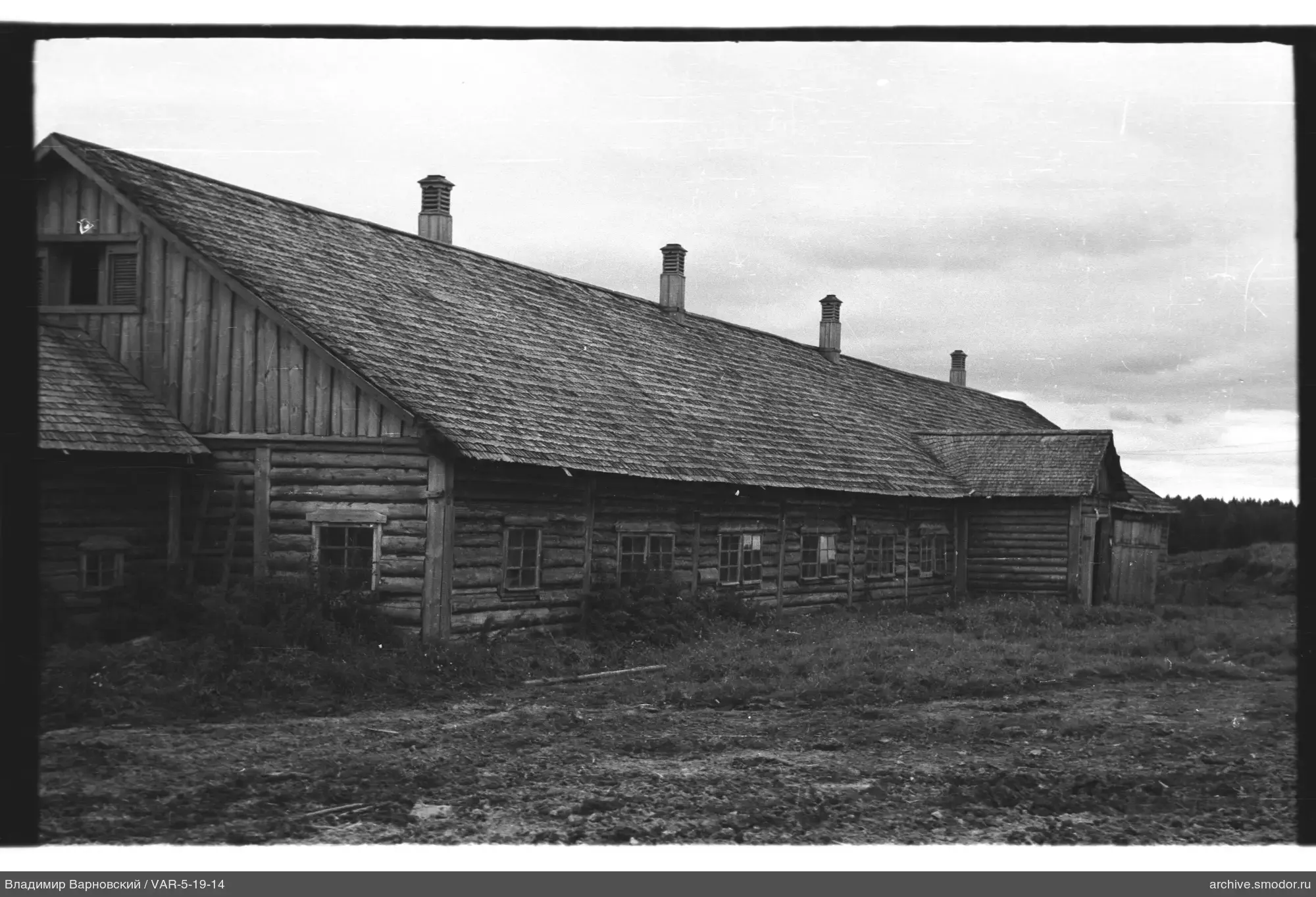Long wooden log building with gable roof