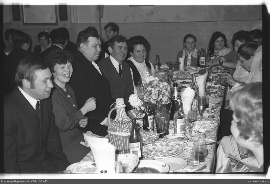Group sitting at a table with dishes and flowers