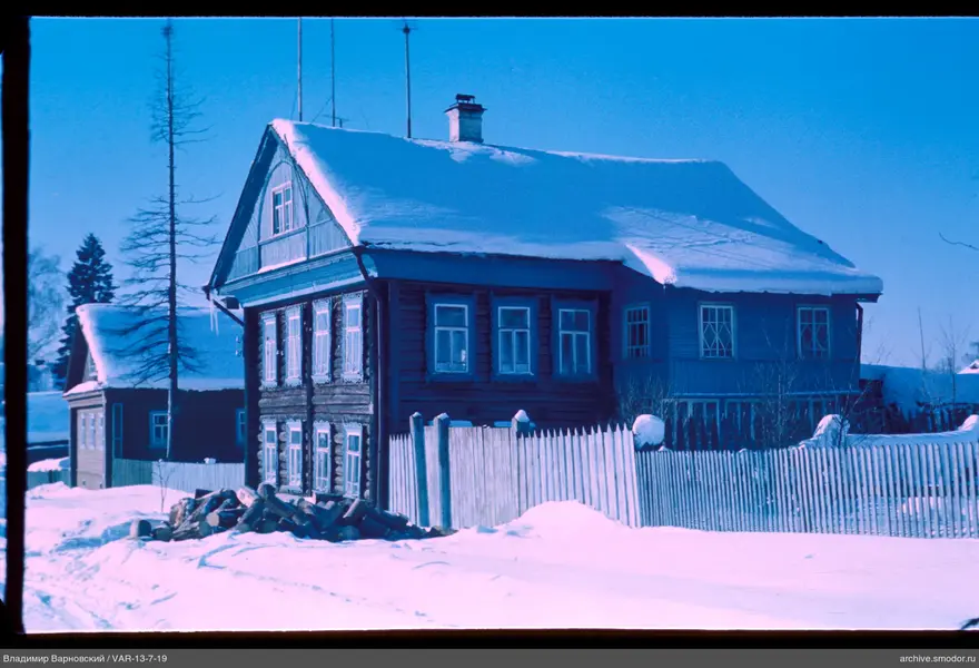 Two wooden houses with snow-covered roofs