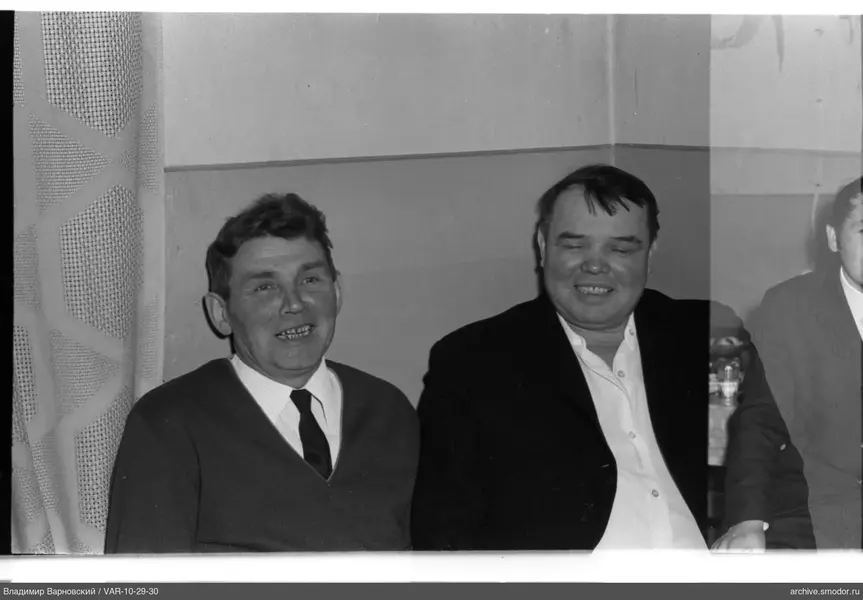Group portrait of three men by the wall
