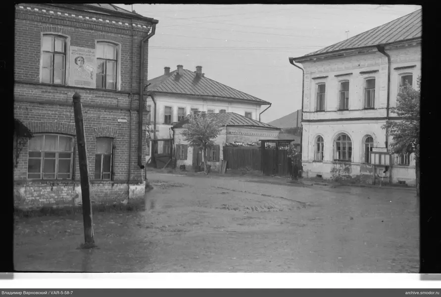 Три здания и дерево на дороге