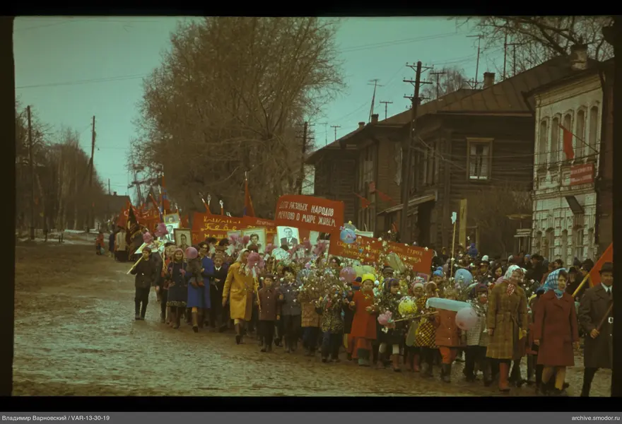 Gruppe von Menschen auf Straße mit Plakaten und Flagge