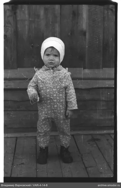 Child portrait in overalls and knitted hat