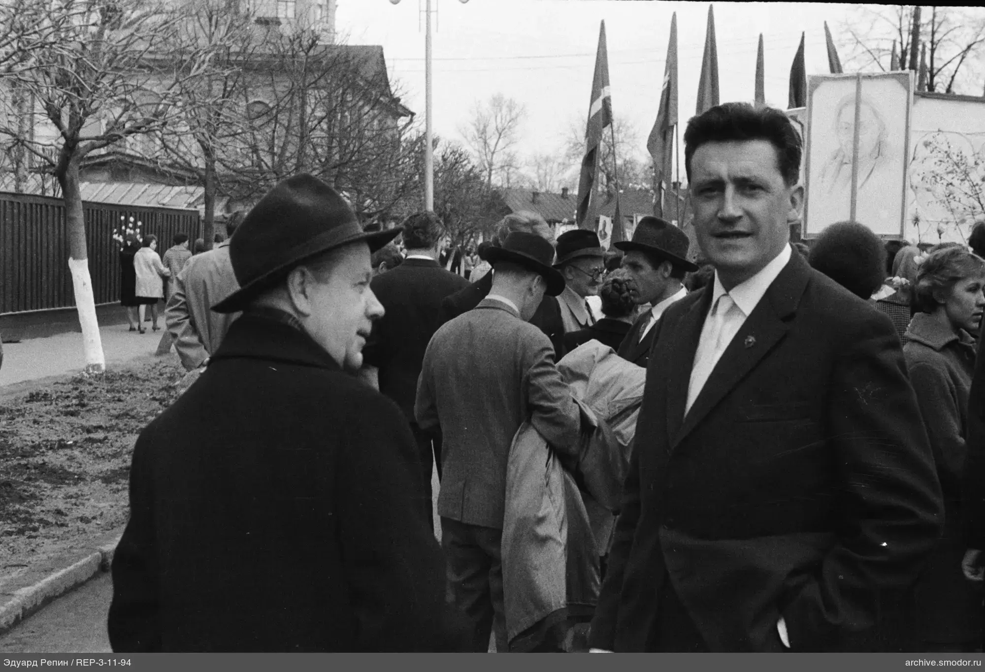 Группа людей на улице с флагами и портретом