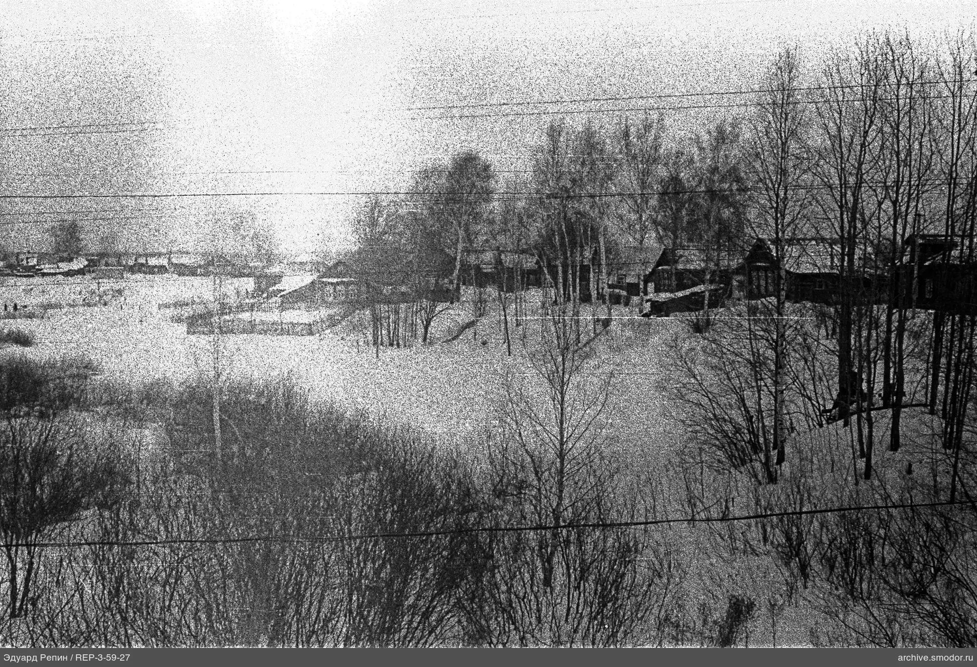 Schneebedeckte Landschaft mit Bäumen und Gebäuden