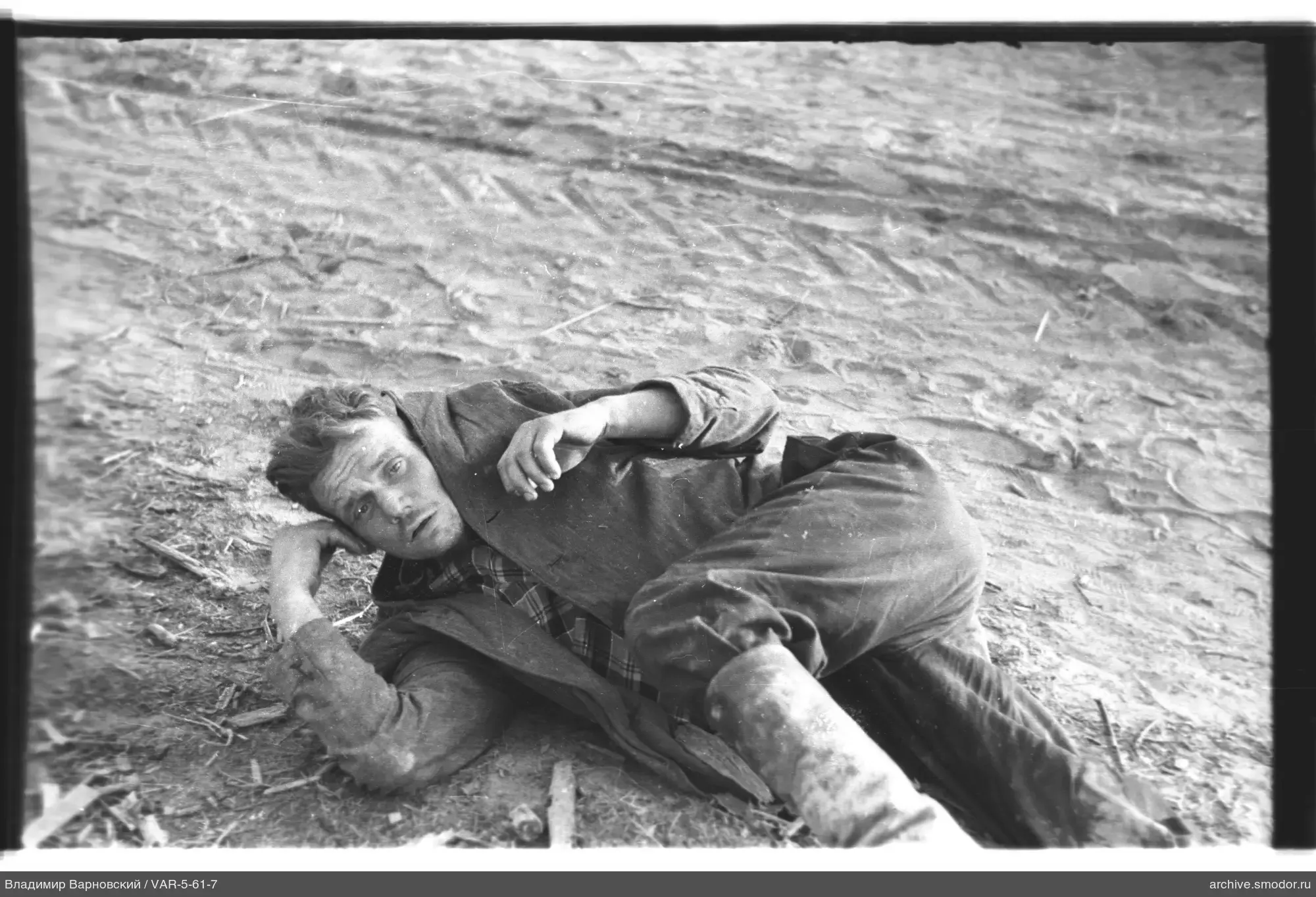 Man lying on the ground with tracks and branches