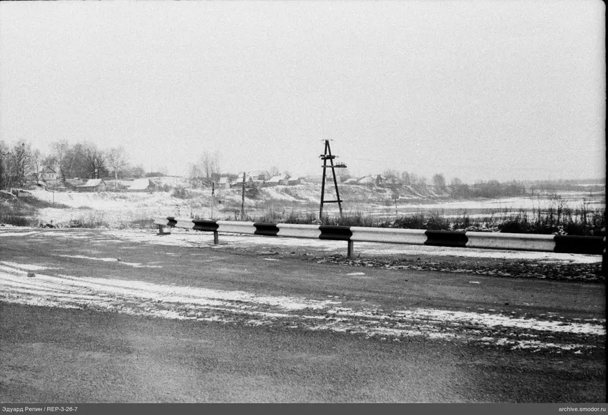 Straße mit Metallbarriere und Strommast