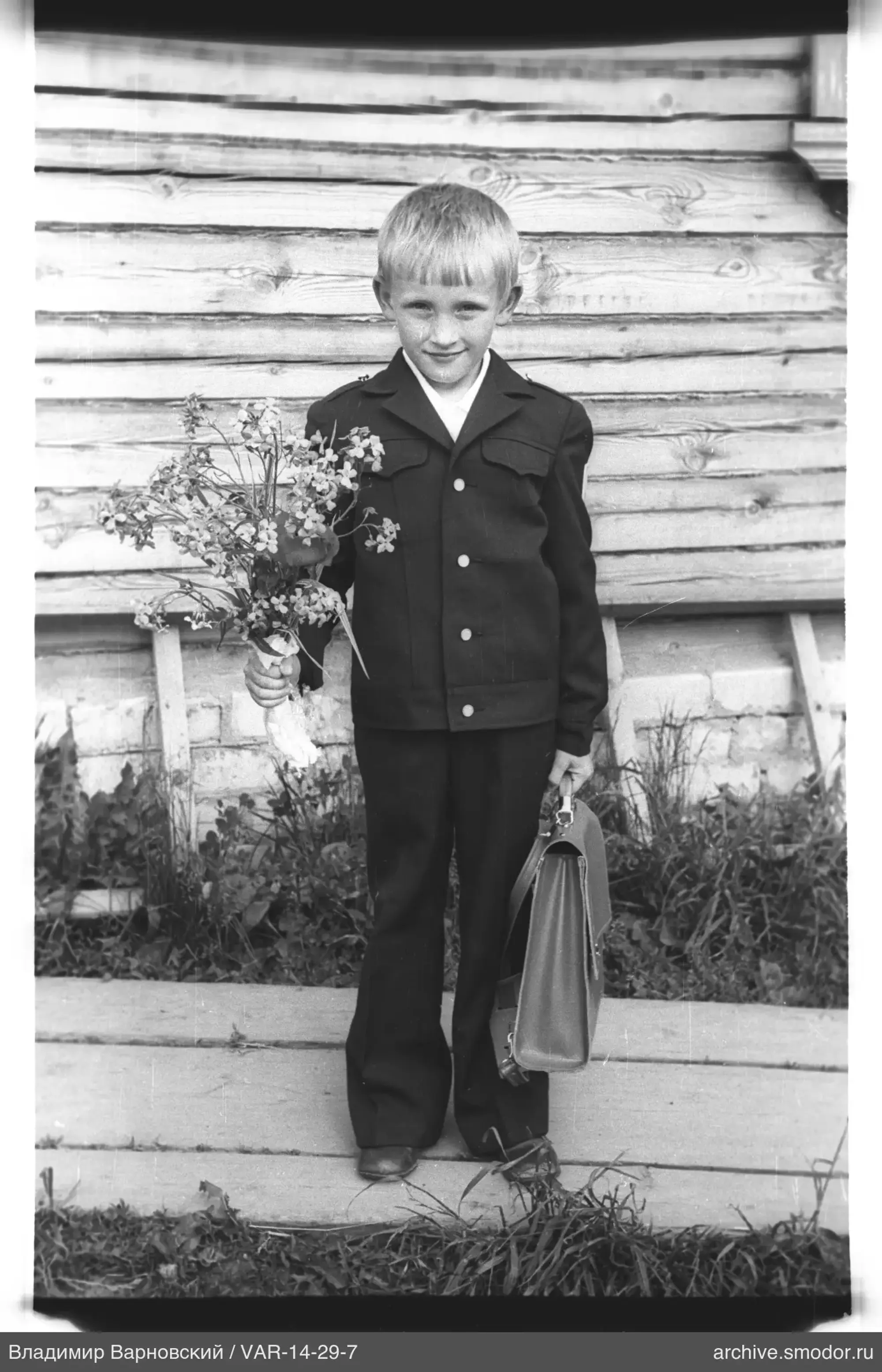 Porträt eines Jungen mit Blumen und Aktentasche