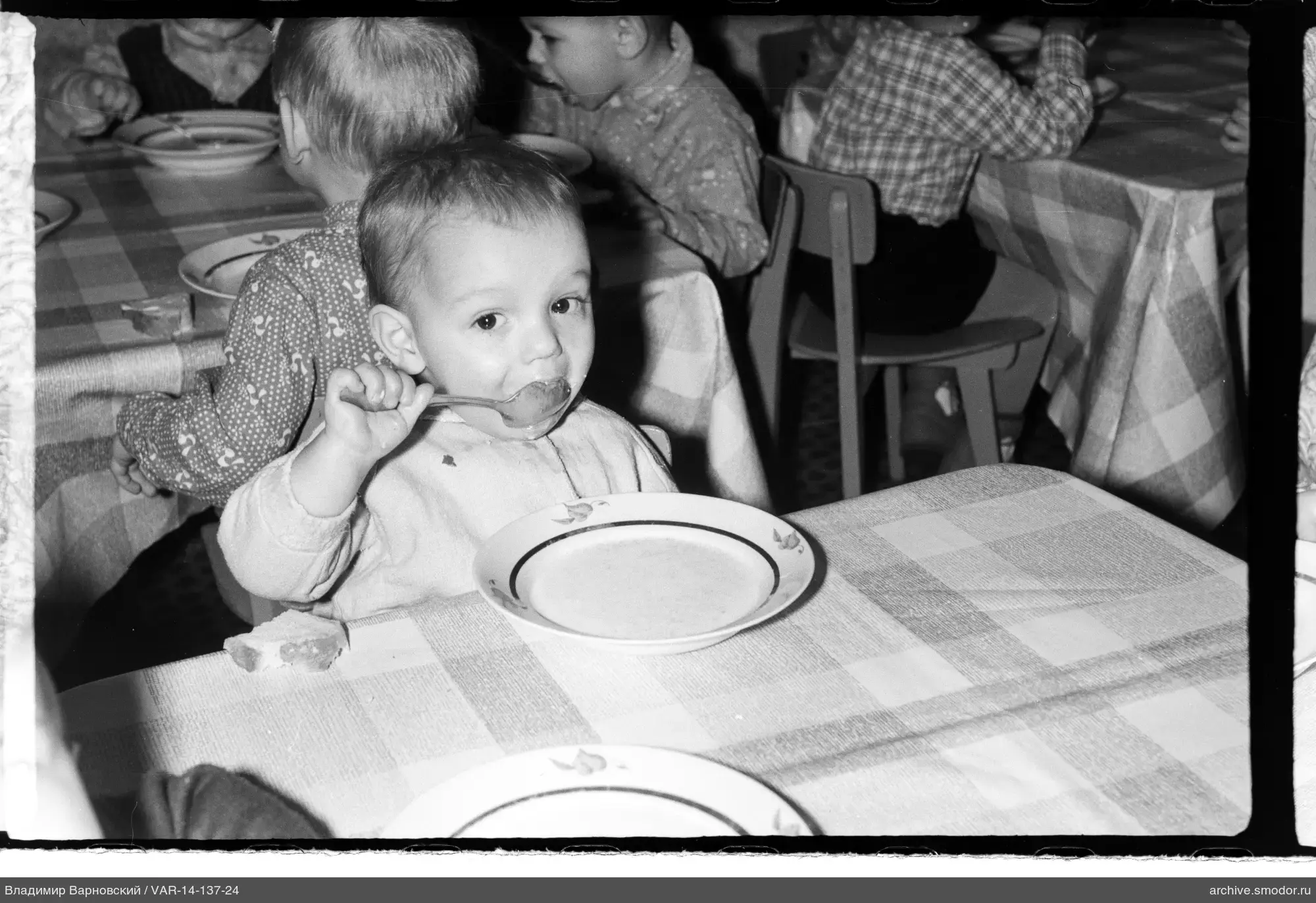 Kinder an Tischen mit Essen
