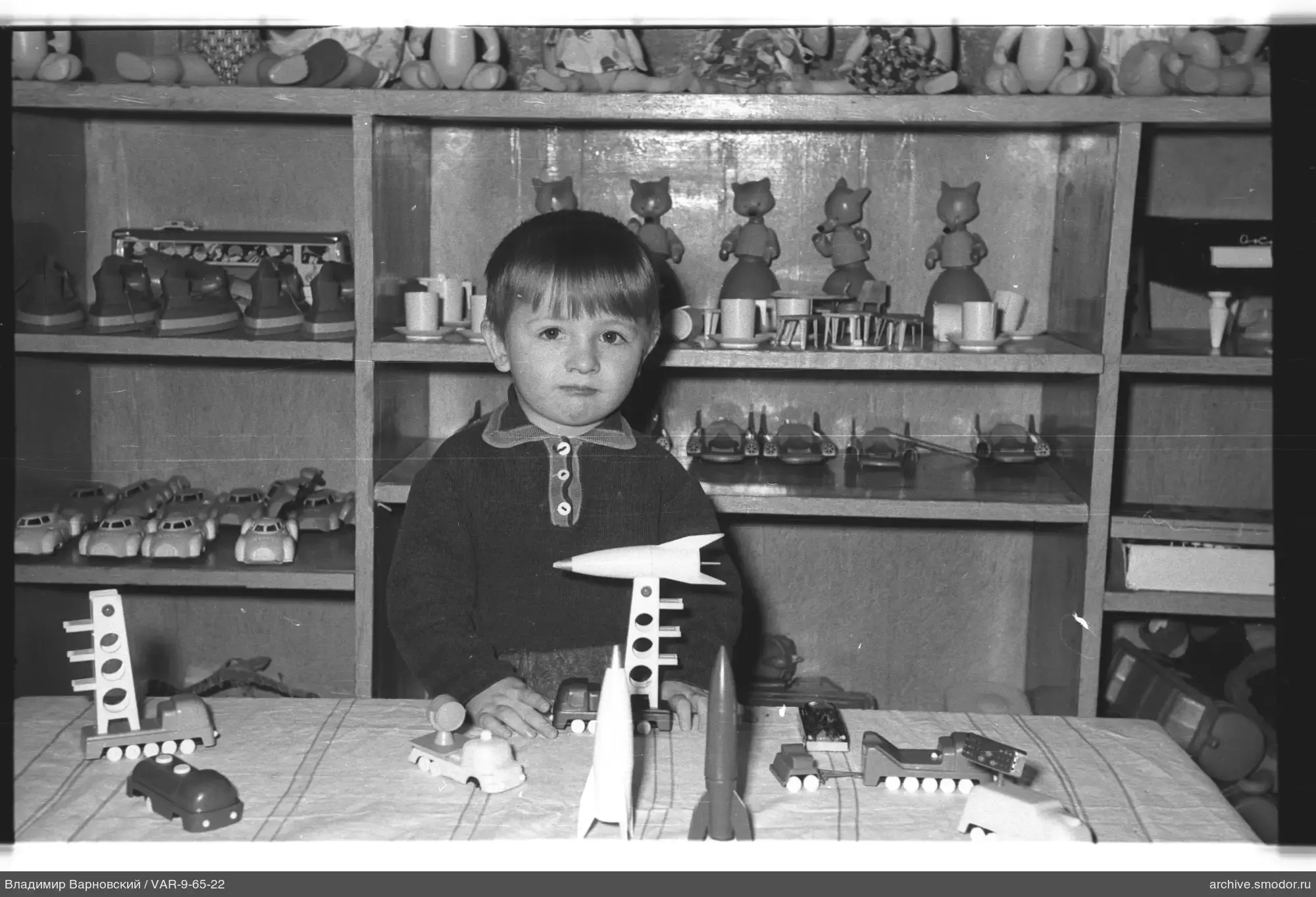 Kind mit Spielzeugmodellen am Tisch
