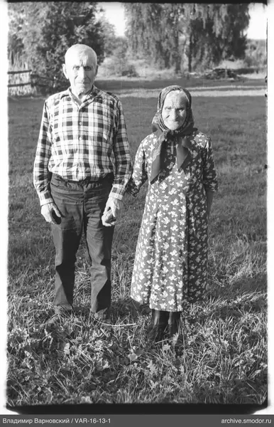 Mann und Frau halten sich an den Händen im Gras