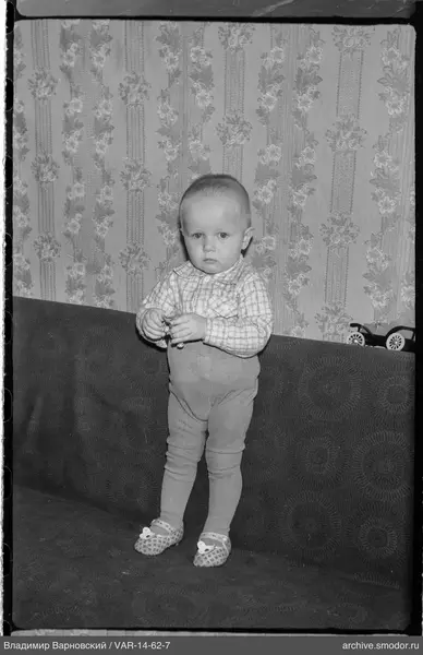 Child standing on sofa with toy